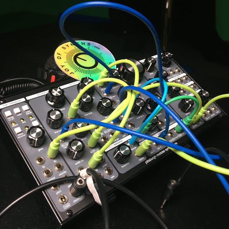 Photo of analog synthesizer with a lot of cables connected.