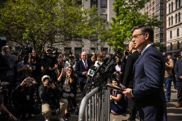 Speaker Mike Johnson speaking into microphones. Photographers and reporters are near. Speaker Mike Johnson speaking into microphones. Photographers and reporters are near.