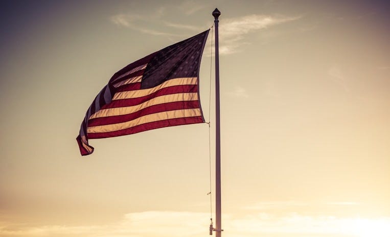 a large american flag flying in the wind