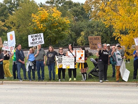 Various protesters and dogs with signs at a NO KINGS rally