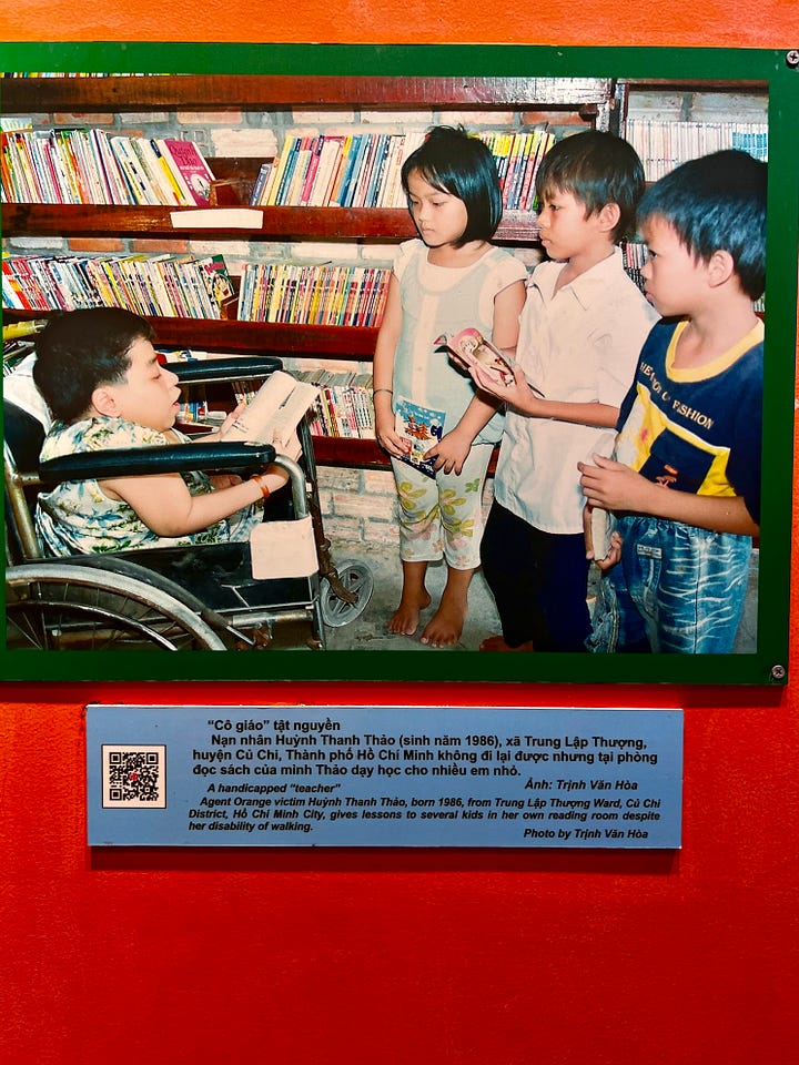 Left: Color photograph showing a young Vietnamese woman in a wheelchair in a library, teaching several children who stand beside her holding books. Bookshelves line the walls behind them. The museum caption identifies her as Huỳnh Thanh Thảo, born in 1986, an Agent Orange victim who became a teacher despite being unable to walk. Right: Museum display showing a letter written in Vietnamese and English to President Barack Obama from Trần Thị Hoan, an Agent Orange victim born in 1986. The letter, dated March 19, 2009, describes her disability and asks Obama to consider the lives of children affected by Agent Orange, noting that the chemical continues killing people long after the war.
