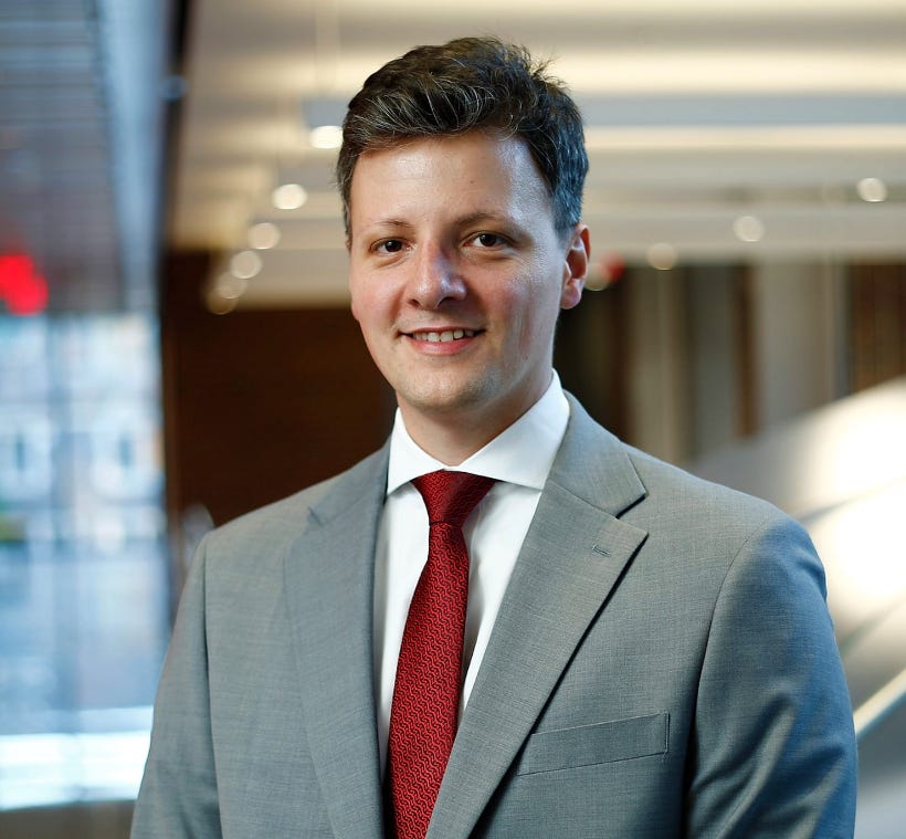 A person in a suit and tie

AI-generated content may be incorrect.