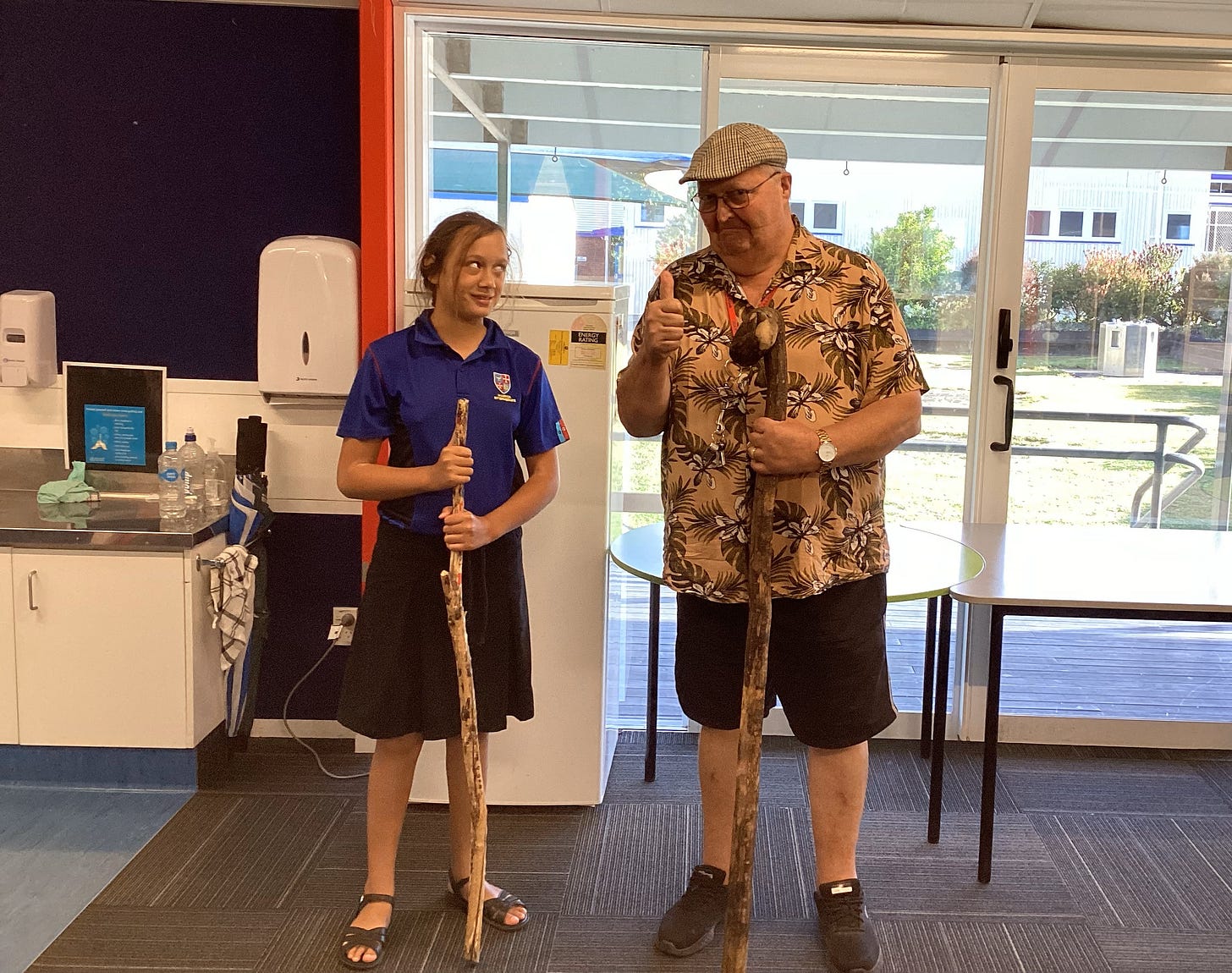 student and matua derek with their walking sticks