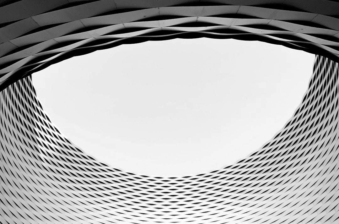 a circular window in a building with a sky in the background a circular window in a building with a sky in the background