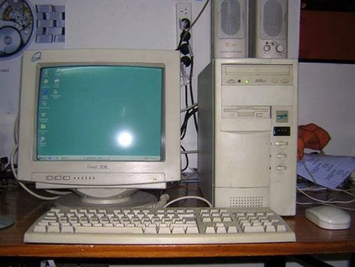 This may contain: an old desktop computer sitting on top of a wooden desk
