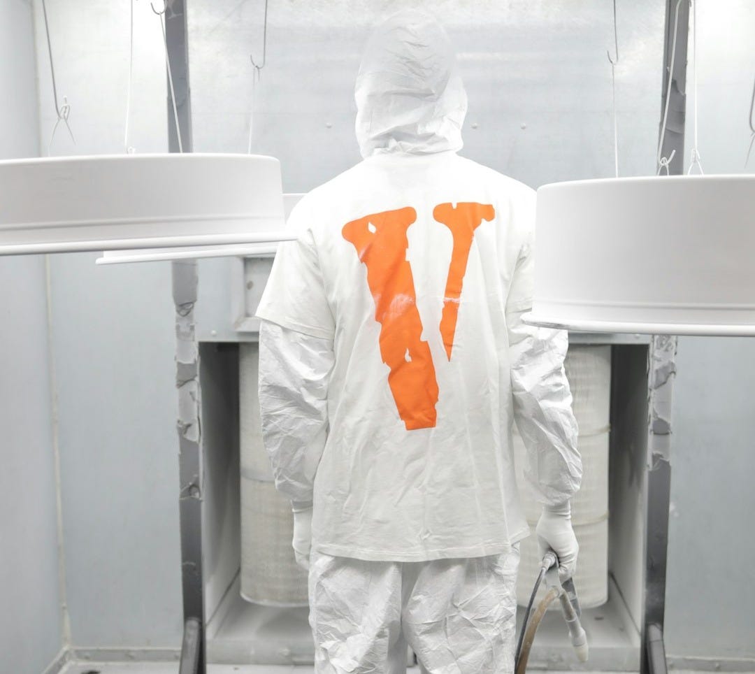 person in white pants and white shirt standing beside white table