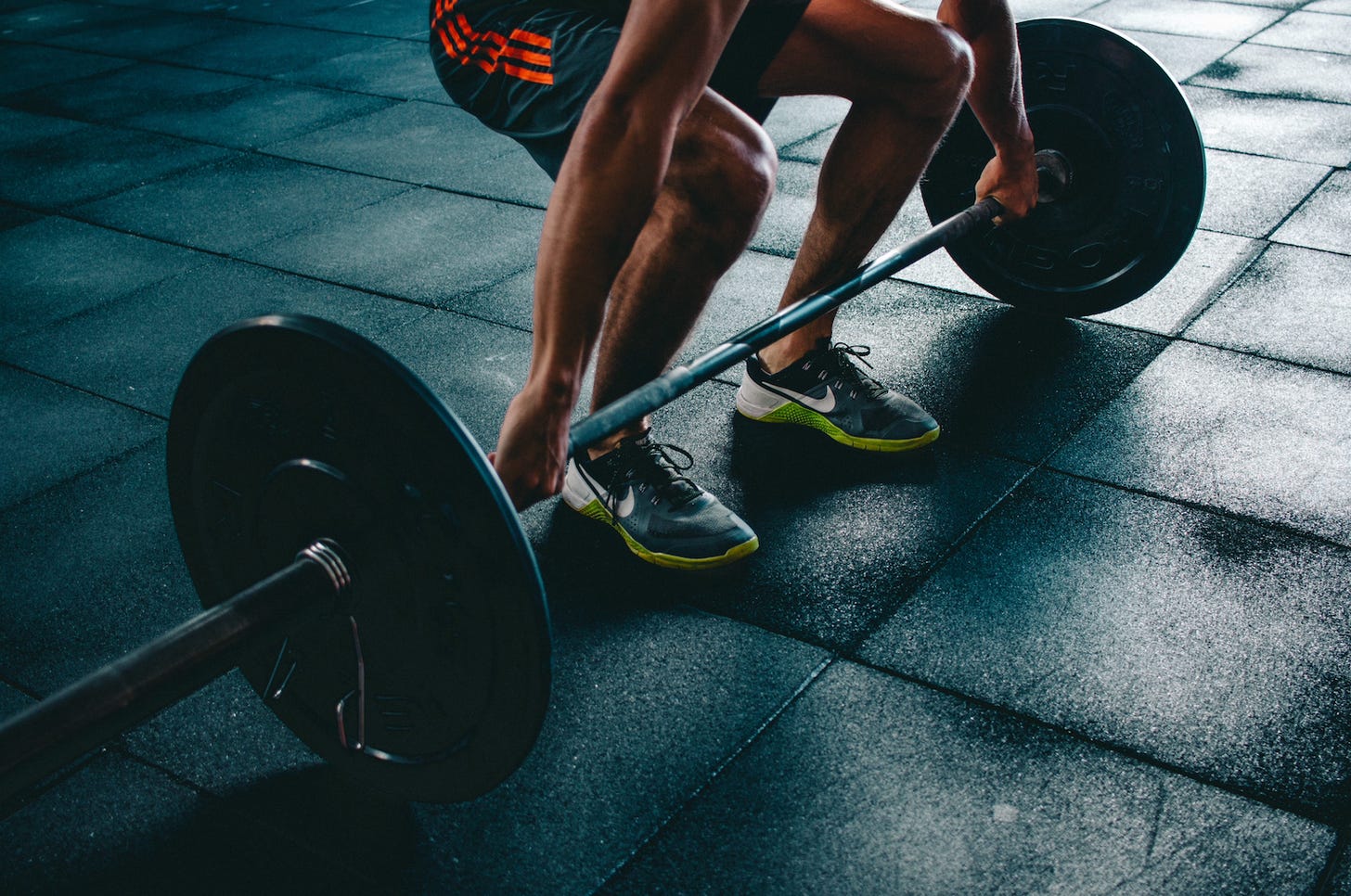An athlete preparing to perform a deadlift in a gym, demonstrating one of the most effective compound exercises for building strength and muscle mass. An athlete preparing to perform a deadlift in a gym, demonstrating one of the most effective compound exercises for building strength and muscle mass.