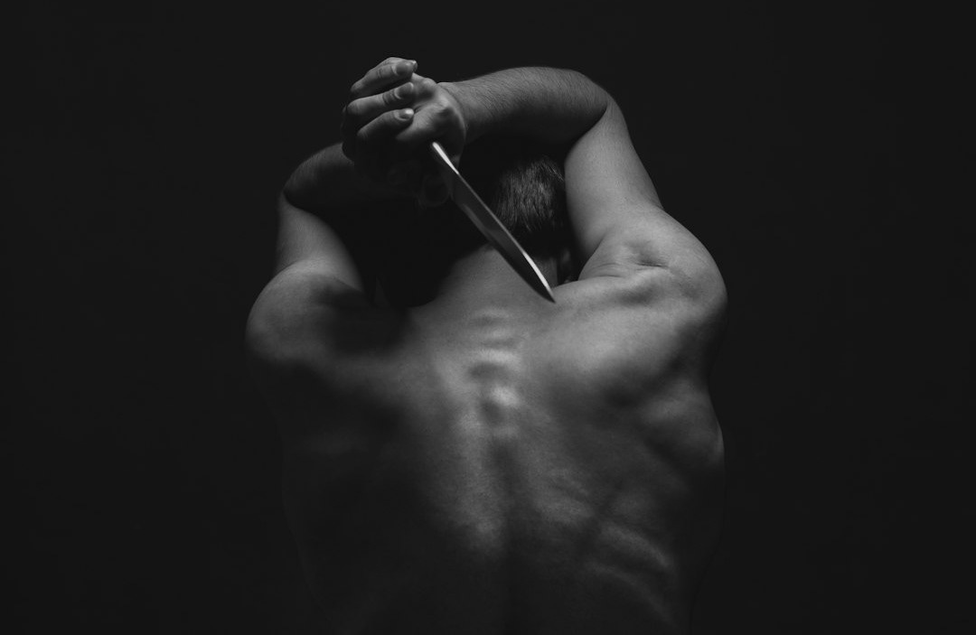 man holding gray dagger