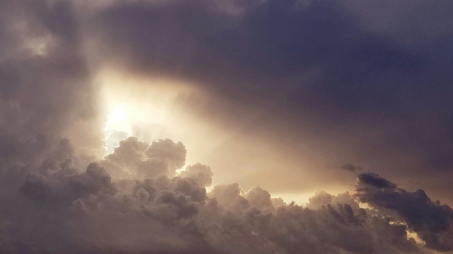 white and grey clouds with sunlight breaking through white and grey clouds with sunlight breaking through