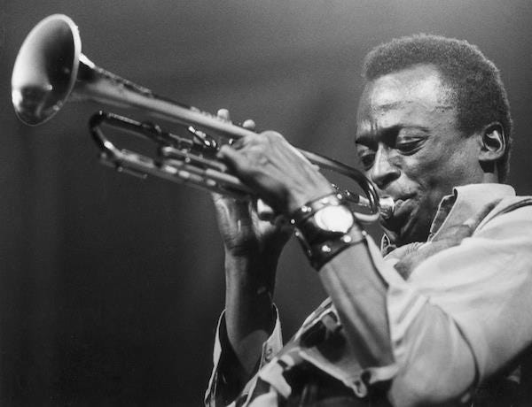 This may contain: a black and white photo of a man playing a trumpet