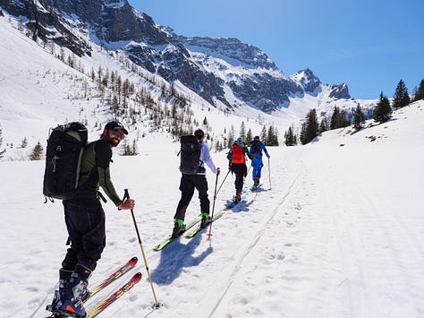 Images of people on ski tour, skinning up in a line behind each other.