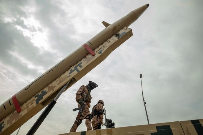 Two Islamic Revolutionary Guard Corps personnel stand under an Iranian Kheibar Shekan Ballistic missile. Two Islamic Revolutionary Guard Corps personnel stand under an Iranian Kheibar Shekan Ballistic missile.