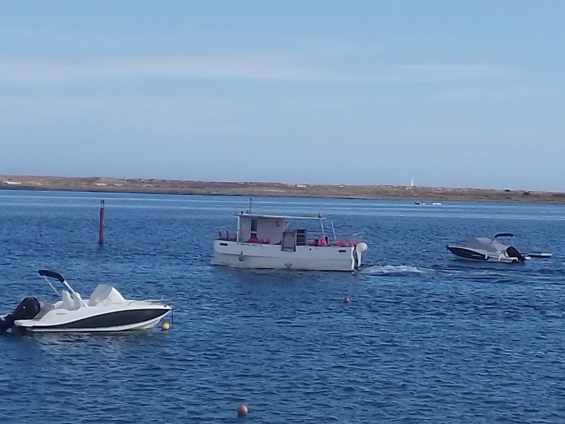Ferry churning its way to the beach with no passengers. Lots of sky. Lots of water. A couple of pleasure boats at anchor. And one very empty, sad little ferry. 