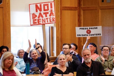 People applaud as others hold signs opposing datacenters People applaud as others hold signs opposing datacenters