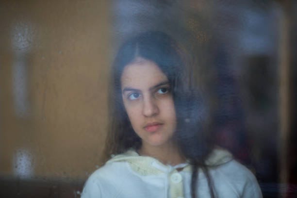 Sad woman looking rain through a window Photo of Sad woman looking the rain falling through a window at home or hotel. Close up of sad depressed teenager spending time alone at home, outdoor photo of young upset pensive woman feeling lonely or frustrated thinking about problems, looking through a window. girl peeping through window stock pictures, royalty-free photos & images Sad woman looking rain through a window Photo of Sad woman looking the rain falling through a window at home or hotel. Close up of sad depressed teenager spending time alone at home, outdoor photo of young upset pensive woman feeling lonely or frustrated thinking about problems, looking through a window. girl peeping through window stock pictures, royalty-free photos & images