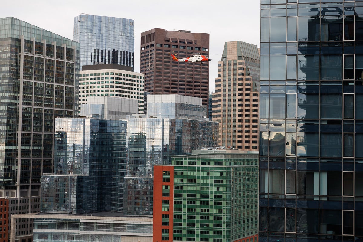 Photo of Coast Guard Helicopter Flying in front of Downtown Boston.