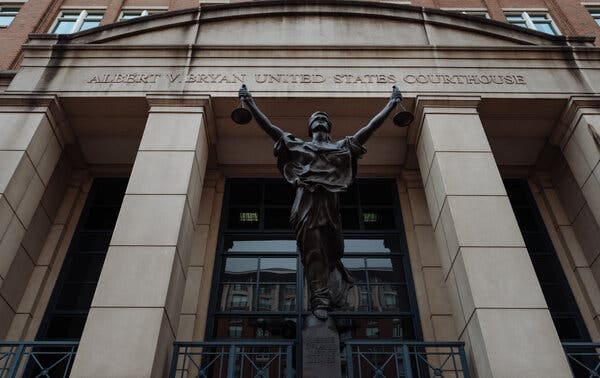 The exterior of the Eastern District of Virginia courthouse with a statue in front of it.
