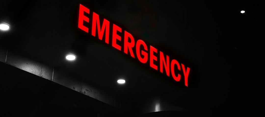 Red emergency sign illuminates a dark building entrance.