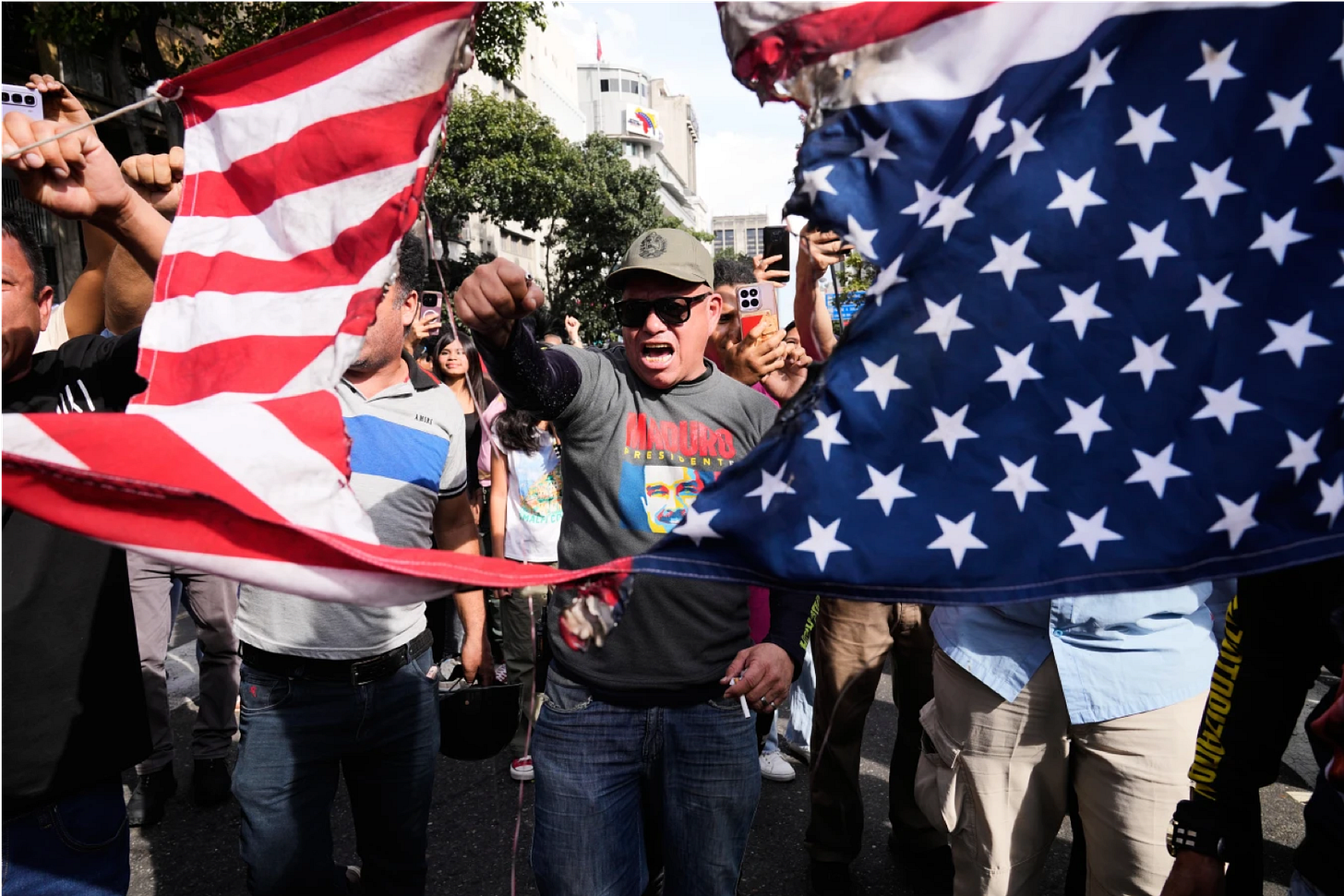 Government supporters rip an American flag in half during a protest in Caracas, Venezuela, Saturday, Jan. 3, 2026, after U.S. President Donald Trump announced that U.S. forces had captured President Nicolás Maduro and first lady Cilia Flores. (AP Photo/Ariana Cubillos)