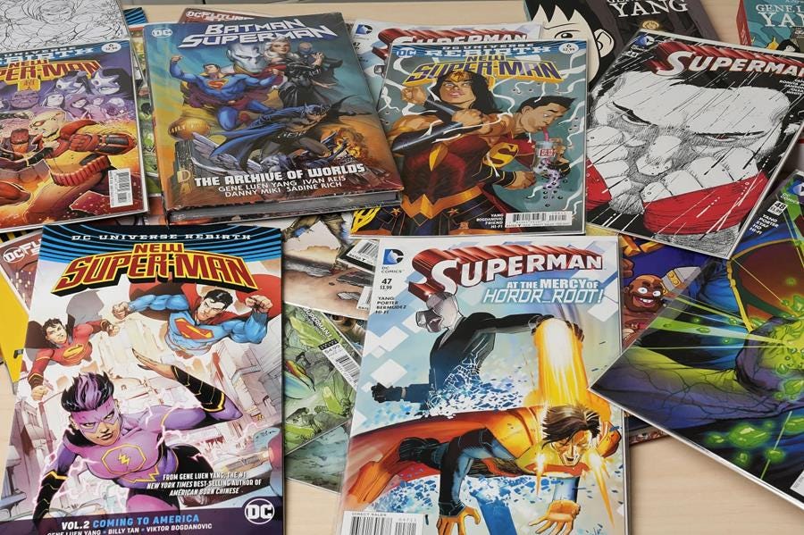 A table covered in different Superman comics from different eras.