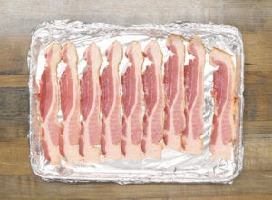 Bacon strips on a sheet pan covered with foil Bacon strips on a sheet pan covered with foil