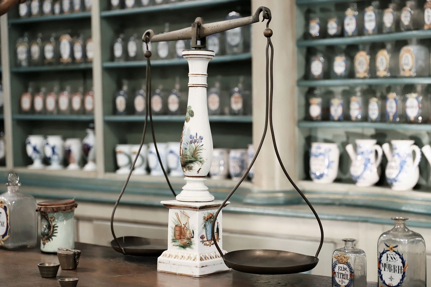 Close-up of antique scales and medicine bottles in a vintage pharmacy setting. (stock photo)
