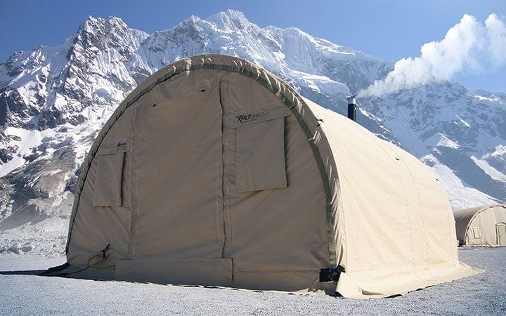 High-altitude expedition tent set beneath snow-covered peaks.