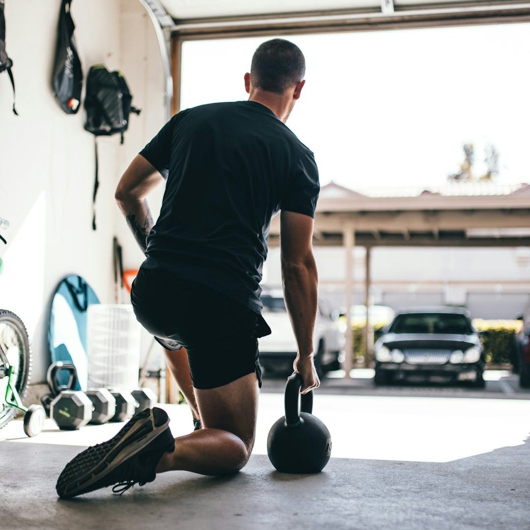 man in black t-shirt and black shorts standing on black and white basketball hoop