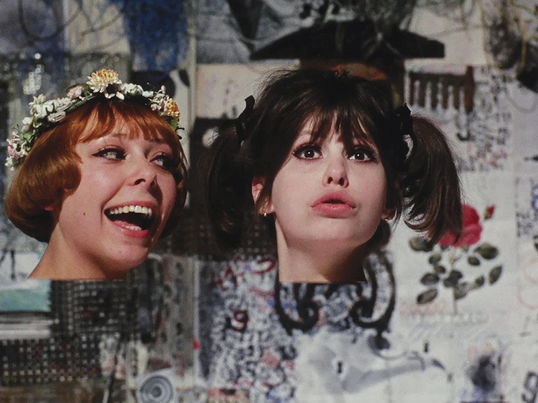 A still frame from Vera Chytilová's 1966 movie Daisies. Two disembodied heads with surprised and joyful expressions are against a chaotic and collaged wallpaper pasted background. The girl on the left has a daisy crown on her head.
