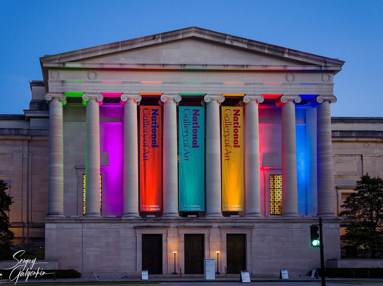 Exterior of the National Gallery of Art in Washington, D.C., lit up with vibrant multicolored lighting at night. Exterior of the National Gallery of Art in Washington, D.C., lit up with vibrant multicolored lighting at night.