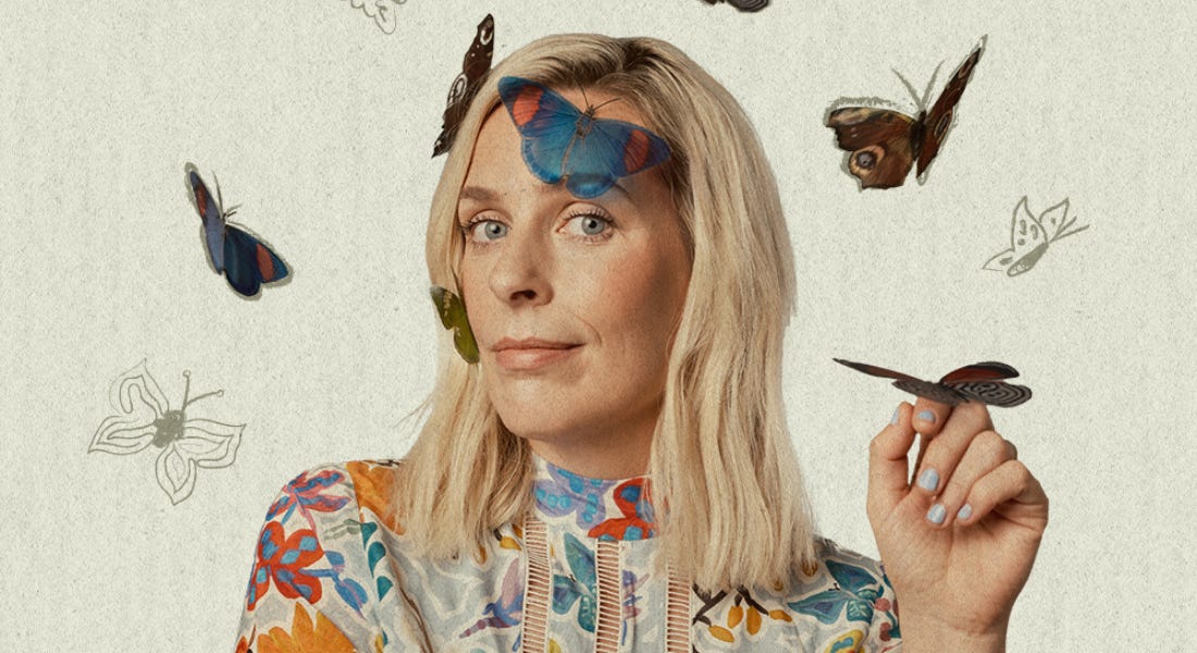 Sara Pascoe wearing a shirt with bright flowers on it, with butterflies flying around her Sara Pascoe wearing a shirt with bright flowers on it, with butterflies flying around her