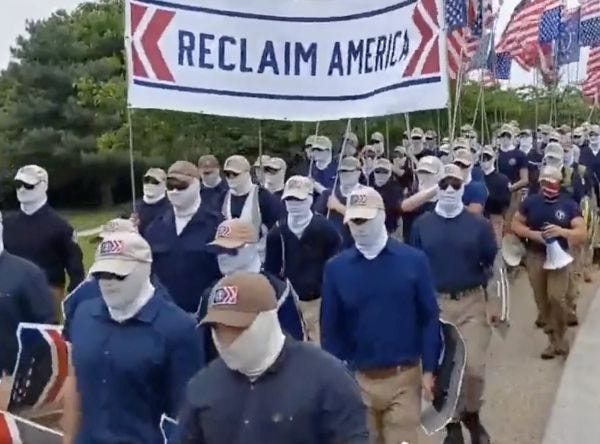 Videos of the group show a pack of roughly 150 masked men in uniforms carrying upside-down American flags (Rawsalerts screengrab)