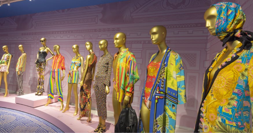 A row of golden mannequins wearing various colourful outfits