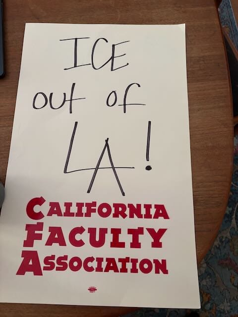 White posterboard with words "ICE Out of LA!" with "California Faculty Association" at the bottom
