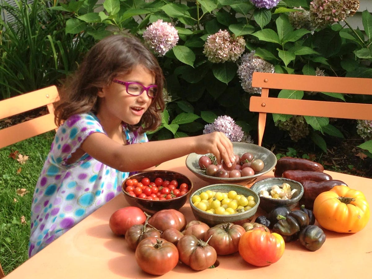 a young girl tasting some freshly-picked veggies