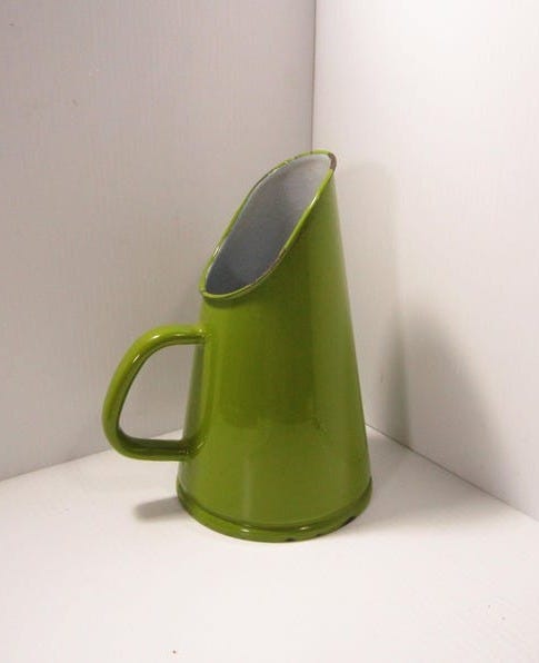 May include: A green enamel pitcher with a silver rim and a handle. The pitcher is shaped like a cone and has a wide opening at the top.