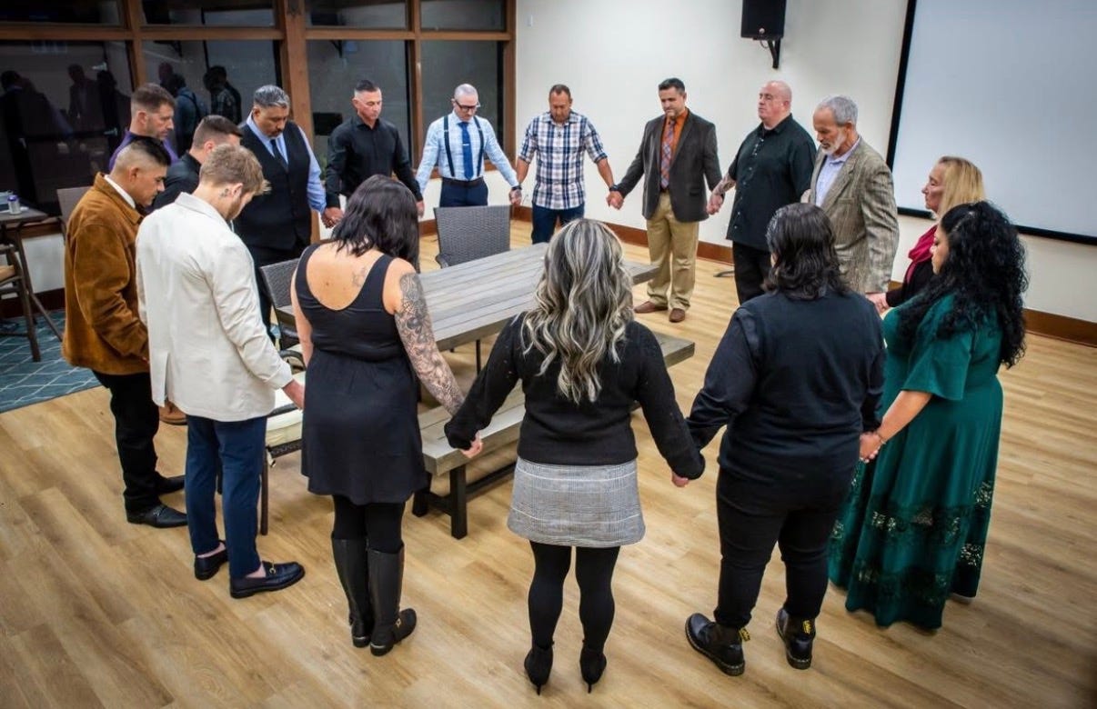 Santa Barbara Rescue Mission Graduation with people holding hands in a circle.
