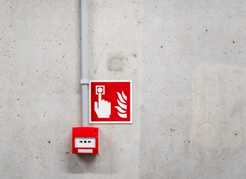 a red and white sign on a concrete wall