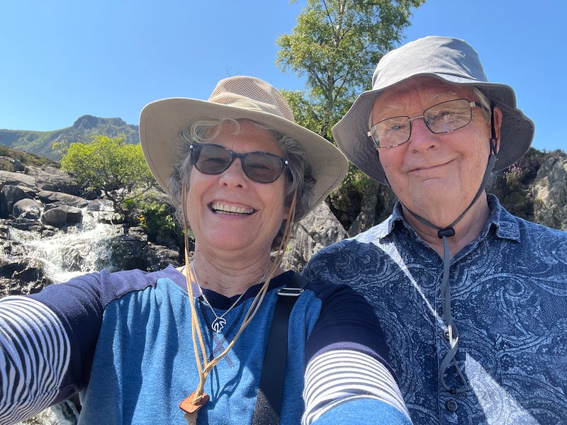 2025-6-19 John and Susan on the trail to Llya Idwal, Wales with the waterfall in the background by Susan Corbin