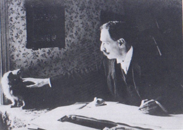 Louis Wain seated at his drawing table