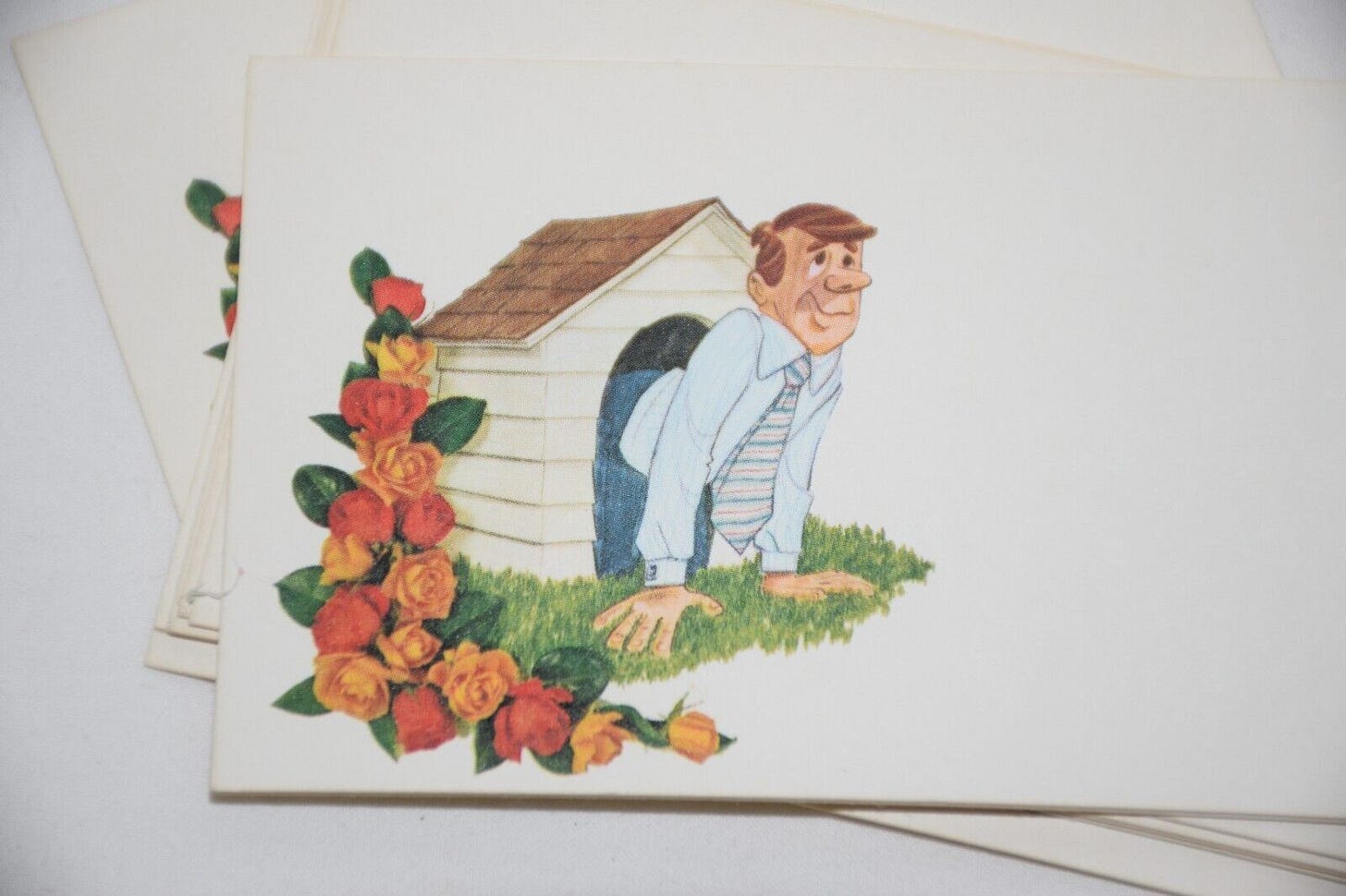 A photo of a florist card with a cartoon person in a doghouse. A photo of a florist card with a cartoon person in a doghouse.