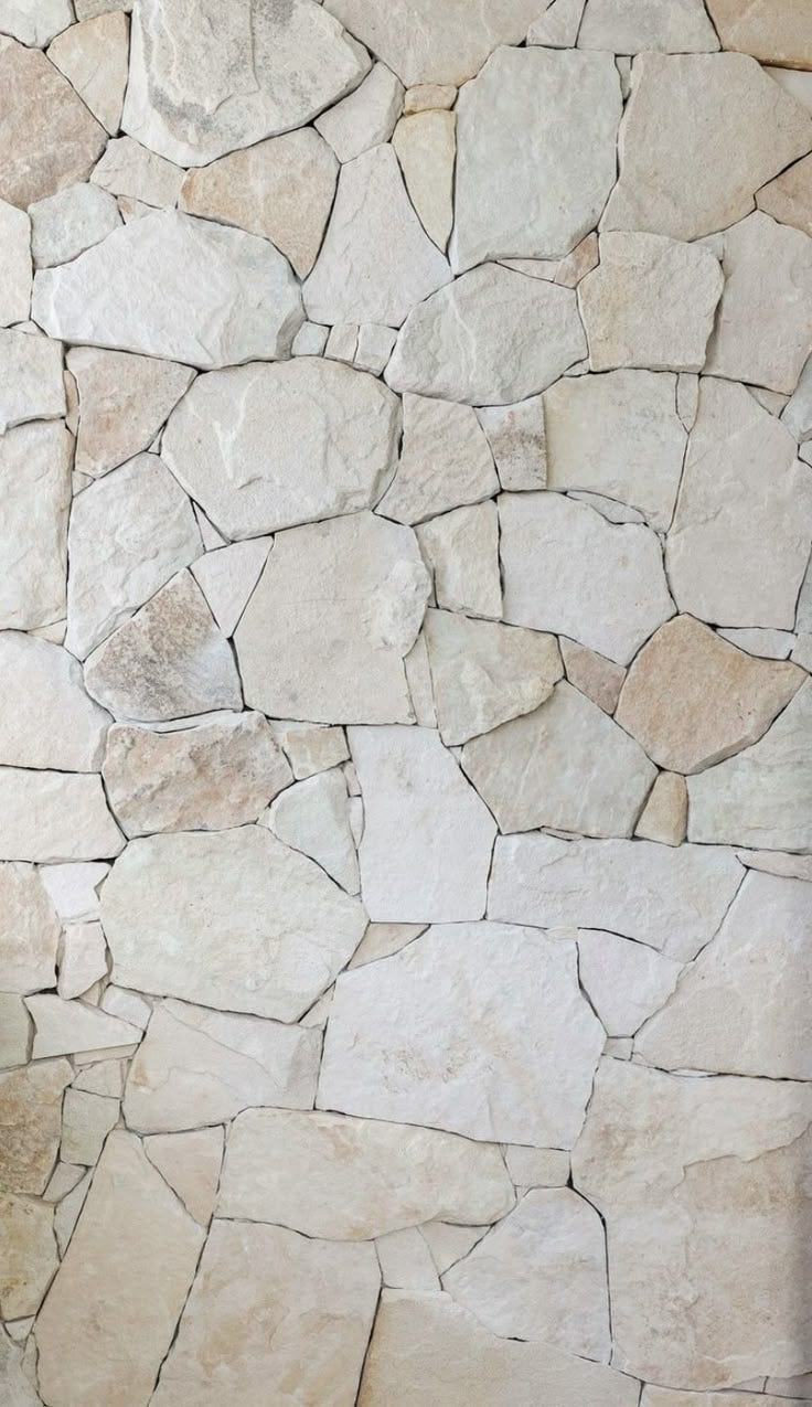 This may contain: a stone wall that is made out of various types of rocks and has no mortar
