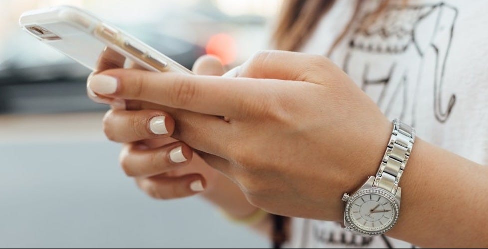 woman holding iPhone during daytime