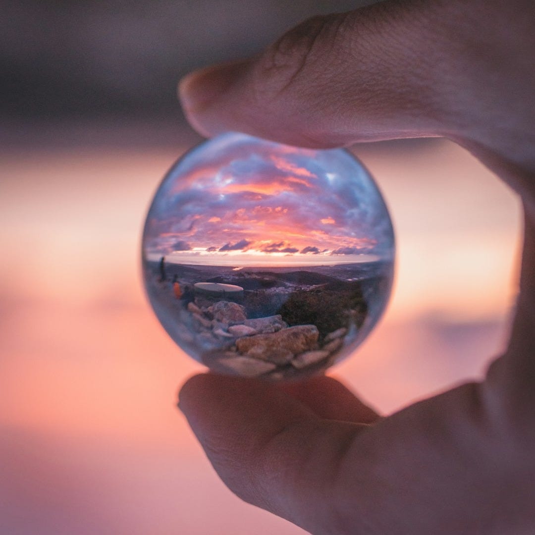 person holding clear glass ball person holding clear glass ball