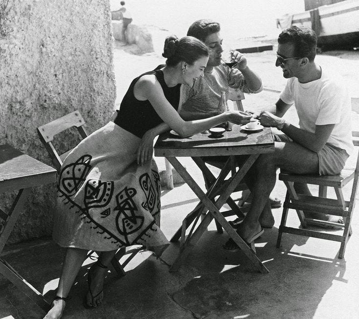 This may contain: black and white photograph of people sitting at a table outside eating food on the patio This may contain: black and white photograph of people sitting at a table outside eating food on the patio