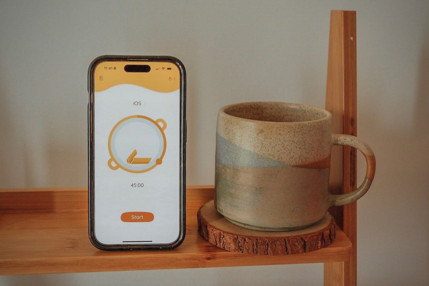 A picture of FocusPasta on my phone, next to my handmade ceramic mug