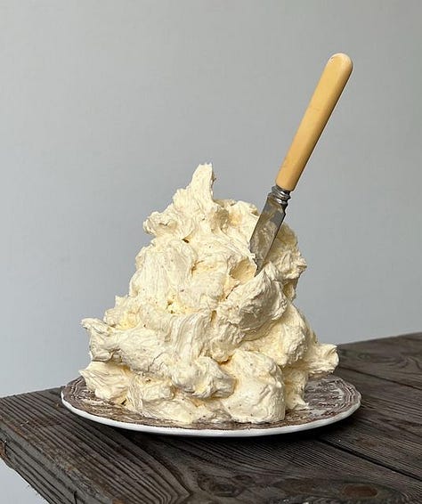 "Whipped butter met een luchtige, romige textuur, geserveerd in een schaaltje naast versgebakken brood."