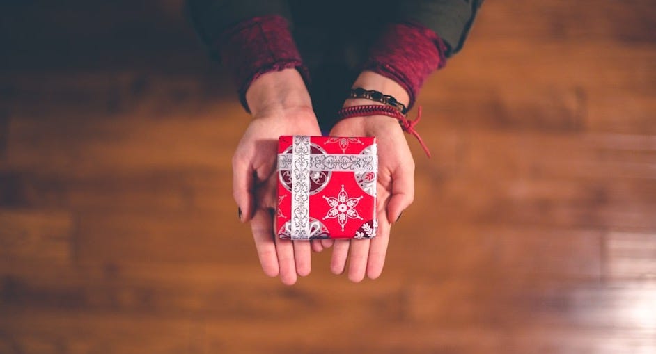 person holding red and white box
