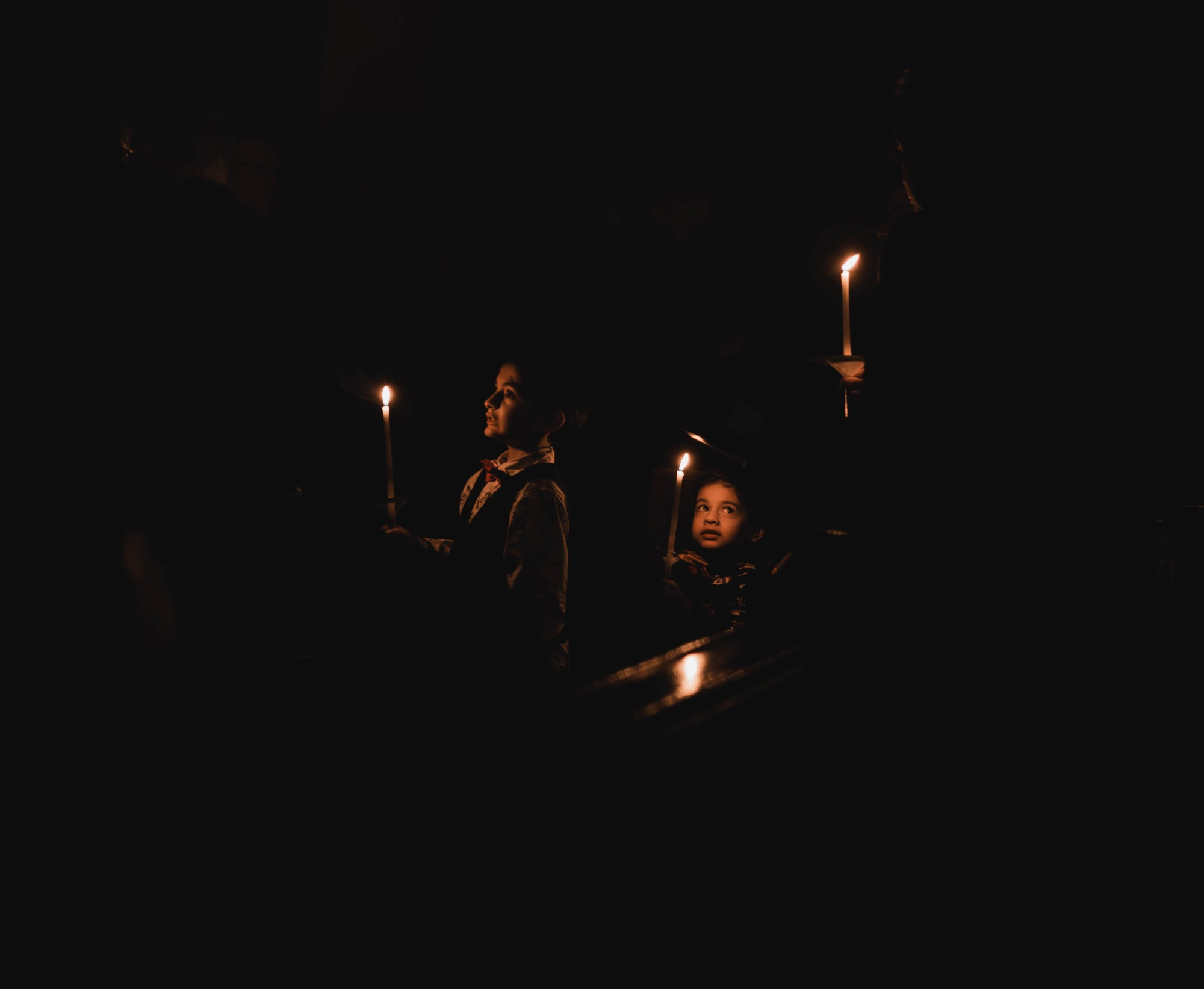 een jongen met kaars kijkt op naar zijn vader