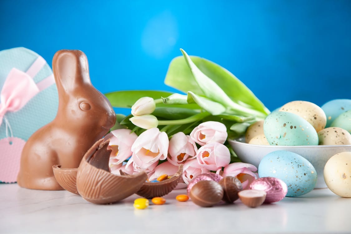 Free A vibrant Easter display featuring a chocolate bunny, pastel eggs, and tulips. Stock Photo Free A vibrant Easter display featuring a chocolate bunny, pastel eggs, and tulips. Stock Photo